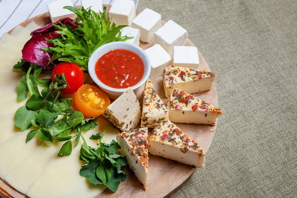 Farklı türde peyniri beyaz peynir-brynza, domates sos ve taze sebze ile yönetim kurulu. Restoran menü plaka