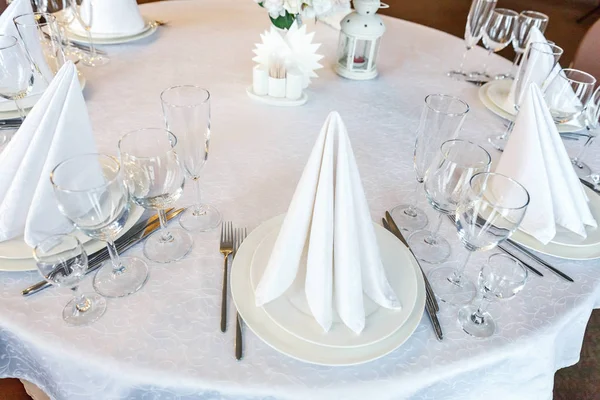 Gözlük, bir piramit katlanmış peçete akşam yemeği için restoran rahat iç görev yaptı. Düğün süslemeleri ve maddeler için gıda, beyaz masa örtüsü ile kaplı büyük bir tabloda catering hizmeti göre düzenlenmiş