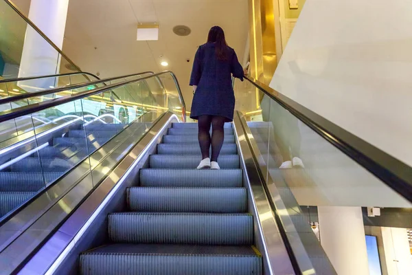 Saint Petersburg, Rusya, 20 Ekim 2017: Kız alışveriş çok düzeyli alışveriş merkezinde yürüyen merdiven üzerinde