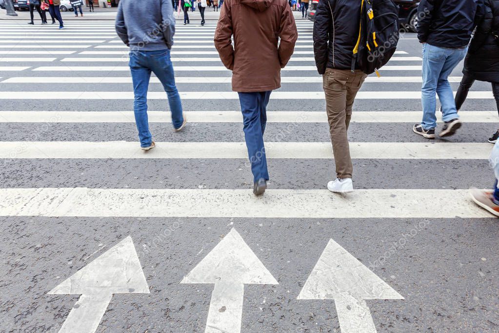 crowds of people is crossing a city street