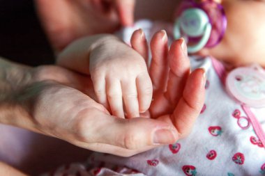 Holding anne el küçük bebeğim. Kadın şekillendirilmiş küçük yeni doğan bebeğin yandan closeup eller. Anne ve çocuk. Mutlu aile kavramı. Annelik güzel kavramsal görüntüsü