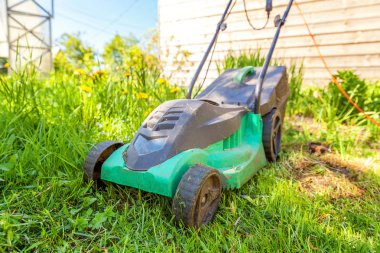 Çim biçme güneşli bir günde bahçede yeşil çim kesme makinesi. Bahçe ülke yaşam tarzı arka plan. Güzel görünüm taze yeşil çim çim güneş ışığı altında bahar ya da yaz sezonu Bahçe Peyzaj
