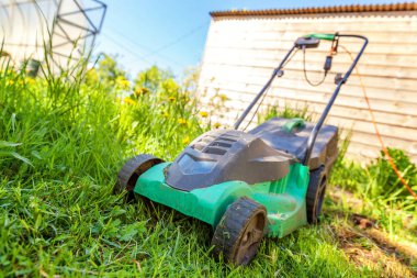Çim biçme güneşli bir günde bahçede yeşil çim kesme makinesi. Bahçe ülke yaşam tarzı arka plan. Güzel görünüm taze yeşil çim çim güneş ışığı altında bahar ya da yaz sezonu Bahçe Peyzaj