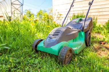 Çim biçme güneşli bir günde bahçede yeşil çim kesme makinesi. Bahçe ülke yaşam tarzı arka plan. Güzel görünüm taze yeşil çim çim güneş ışığı altında bahar ya da yaz sezonu Bahçe Peyzaj