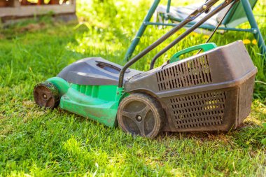 Çim biçme güneşli bir günde bahçede yeşil çim kesme makinesi. Bahçe ülke yaşam tarzı arka plan. Güzel görünüm taze yeşil çim çim güneş ışığı altında bahar ya da yaz sezonu Bahçe Peyzaj