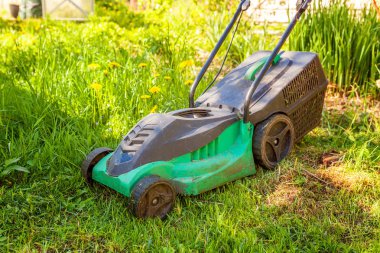 Çim biçme güneşli bir günde bahçede yeşil çim kesme makinesi. Bahçe ülke yaşam tarzı arka plan. Güzel görünüm taze yeşil çim çim güneş ışığı altında bahar ya da yaz sezonu Bahçe Peyzaj