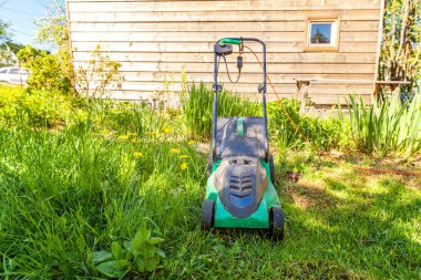 Çim biçme güneşli bir günde bahçede yeşil çim kesme makinesi. Bahçe ülke yaşam tarzı arka plan. Güzel görünüm taze yeşil çim çim güneş ışığı altında bahar ya da yaz sezonu Bahçe Peyzaj