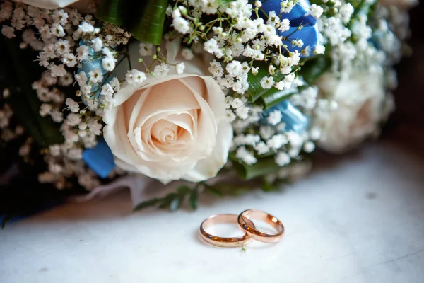 Gyönyörű Esküvő Gyűrű Feküdjön Egy Asztal Egy Csokor Virágot Háttérrel — Stock Fotó