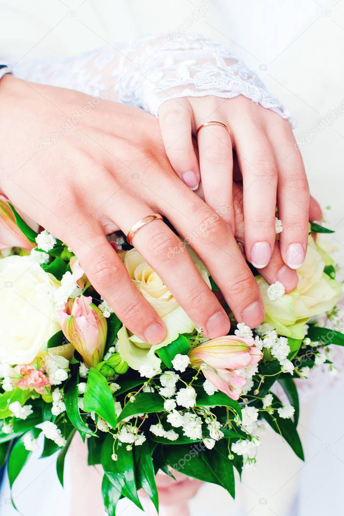 Bride and groom with wedding rings and bridal bouquet