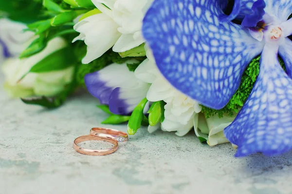 Gyönyörű Esküvő Gyűrű Feküdjön Egy Asztal Egy Csokor Virágot Háttérrel — Stock Fotó