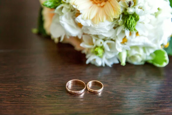 Beautiful Wedding Rings Lie Table Background Bouquet Flowers — Stock Photo, Image