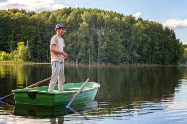 Bir balıkçı güzel bir göle ahşap bir teknede Balık tutma