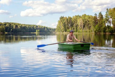 Bir balıkçı güzel bir göle ahşap bir teknede Balık tutma