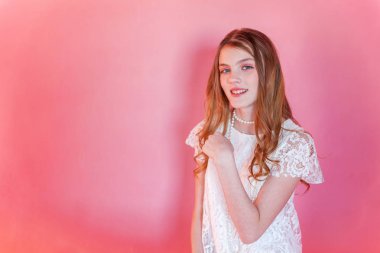 Mutlu genç kız gülümsüyor. Beyaz elbise ayakta pembe renkli pastel trendy modern moda pin-up arka plan üzerinde giyen portre portre genç mutlu pozitif kadın. Avrupa kadın. Olumlu insan duygu yüz ifadesi beden dili