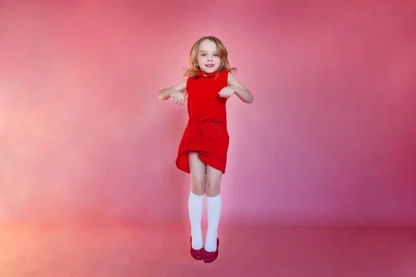 Liten Söt Söt Leende Flicka Röd Klänning Hoppning Rosa Färgglada — Stockfoto
