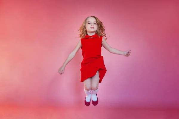 Pouco Bonito Doce Sorridente Menina Vestido Vermelho Saltando Rosa Colorido — Fotografia de Stock