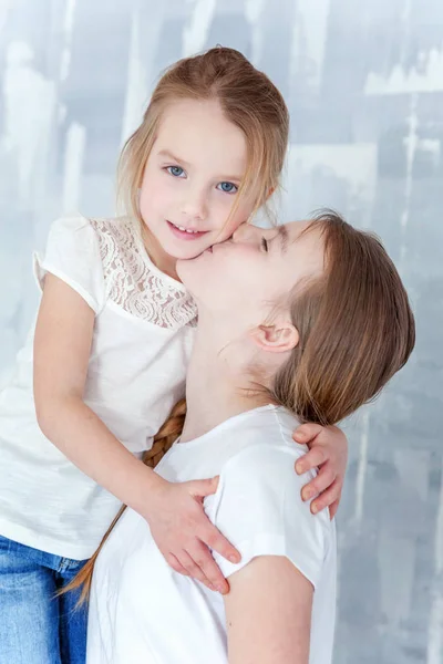 Duas Crianças Felizes Contra Fundo Parede Texturizado Cinza Abraçando Adorável — Fotografia de Stock