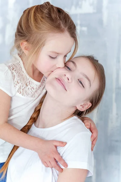 Deux Enfants Heureux Debout Contre Fond Mur Texturé Gris Embrassant — Photo