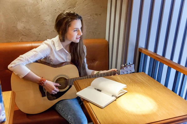 Jovem Sorrindo Hipster Mulher Sentada Tocando Guitarra Escrever Uma Música — Fotografia de Stock