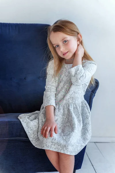 Tatlı Küçük Kız Evde Gri Elbiseli Modern Rahat Mavi Sandalye — Stok fotoğraf