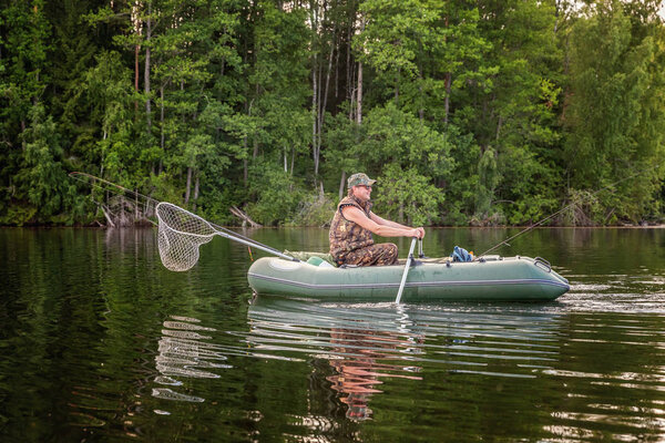 A fisherman is fishing in a boat on a beautiful lake