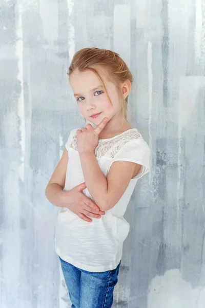 灰色のテクスチャ壁背景空白の白い シャツ立って甘い幸せな少女 — ストック写真