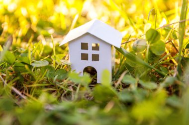 Minyatür beyaz oyuncak model çayır çimen ile evde. Eko Köyü, çevre arka plan. Emlak mortgage Emlak sigorta rüya ev ekoloji kavramı