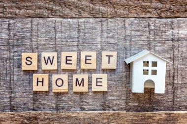 Minyatür oyuncak model evde yazıt Sweet Home harf kelime ahşap zemin üzerinde. Eko Köyü, çevre arka plan. Emlak mortgage Emlak sigorta ekoloji kavramı