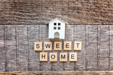 Minyatür oyuncak model evde yazıt Sweet Home harf kelime ahşap zemin üzerinde. Eko Köyü, çevre arka plan. Emlak mortgage Emlak sigorta ekoloji kavramı