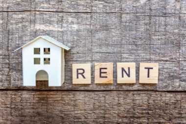 Minyatür oyuncak model ev kira harf kelime ahşap zemin üzerinde yazıt ile. Eko Köyü, çevre arka plan. Emlak mortgage Emlak sigorta tatlı ev ekoloji kira kavramı