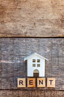 Minyatür oyuncak model ev kira harf kelime ahşap zemin üzerinde yazıt ile. Eko Köyü, çevre arka plan. Emlak mortgage Emlak sigorta tatlı ev ekoloji kira kavramı