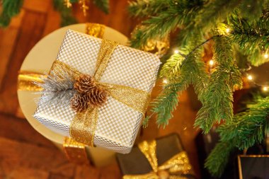 Klasik Noel yeni yıl altın kağıt hediye kutusu Noel ağacı yakınındaki altın şerit yay ile dekore edilmiştir. Modern karanlık klasik tarzı iç tasarım Daire. Noel arifesi evde