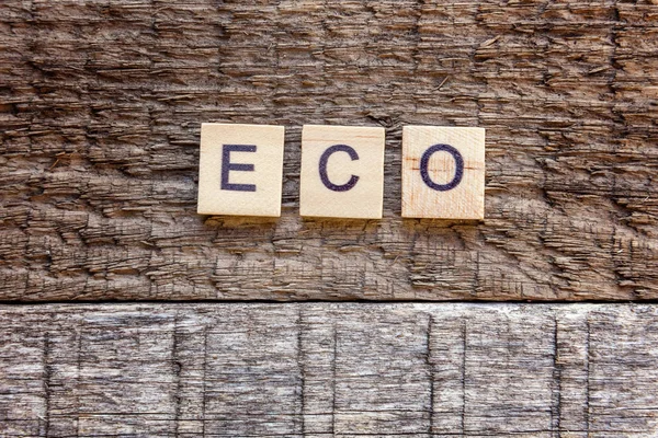 Inscription ECO letters word on old rustic wooden backdrop. Eco Village abstract environmental background. Nature protection energy saving ecology concept. Flat lay top view copy space