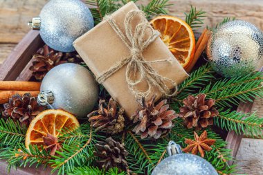 Yılbaşı yeni yıl kompozisyon kış nesneleri kutusunu köknar şube çam kozalakları tarçın sopa eski püskü rustik ahşap arka plan üzerinde hediye. Xmas tatil Aralık dekorasyon. Düz yatıyordu üstten görünüm kopya alanı