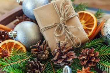 Yılbaşı yeni yıl kompozisyon kış nesneleri kutusunu köknar şube çam kozalakları tarçın sopa eski püskü rustik ahşap arka plan üzerinde hediye. Xmas tatil Aralık dekorasyon. Düz yatıyordu üstten görünüm kopya alanı