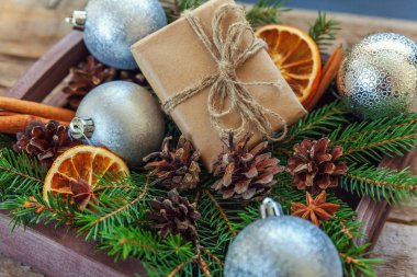 Yılbaşı yeni yıl kompozisyon kış nesneleri kutusunu köknar şube çam kozalakları tarçın sopa eski püskü rustik ahşap arka plan üzerinde hediye. Xmas tatil Aralık dekorasyon. Düz yatıyordu üstten görünüm kopya alanı