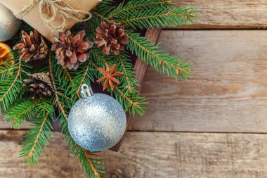 Yılbaşı yeni yıl kompozisyon kış nesneleri kutusunu köknar şube çam kozalakları tarçın sopa eski püskü rustik ahşap arka plan üzerinde hediye. Xmas tatil Aralık dekorasyon. Düz yatıyordu üstten görünüm kopya alanı