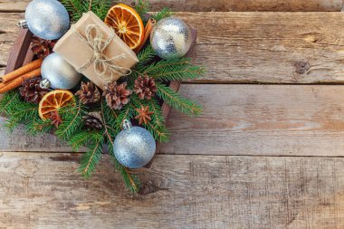 Yılbaşı yeni yıl kompozisyon kış nesneleri kutusunu köknar şube çam kozalakları tarçın sopa eski püskü rustik ahşap arka plan üzerinde hediye. Xmas tatil Aralık dekorasyon. Düz yatıyordu üstten görünüm kopya alanı