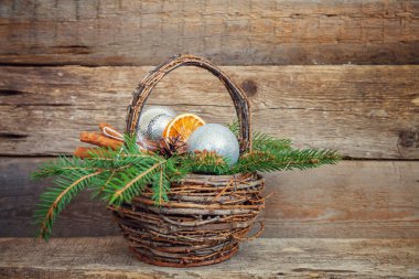 Yılbaşı yeni yıl kompozisyon kış nesneleri köknar dalı sepet çam kozalakları tarçın eski püskü rustik ahşap arka plan üzerinde toplar. Xmas tatil Aralık dekorasyon kopyalama alanı