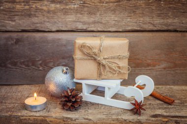 Yılbaşı yeni yıl kompozisyon kış nesneleri kutusunu çam koni topları mum ve eski püskü rustik ahşap arka plan kızağa hediye. Xmas tatil Aralık dekorasyon alanı kopyalayın. Kutlama zamanı