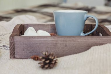 Bir fincan kahve rustik ahşap tepsi, tatlı şekerleme ve sıcak yün kazak. Rahat sonbahar ya da kış hafta sonu veya tatil evde. Sıcak bir içecek kupa ile Güz ev dekorasyon. Hygge sabah tarzı kavramı