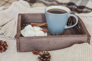 Bir fincan kahve rustik ahşap tepsi, tatlı şekerleme ve sıcak yün kazak. Rahat sonbahar ya da kış hafta sonu veya tatil evde. Sıcak bir içecek kupa ile Güz ev dekorasyon. Hygge sabah tarzı kavramı