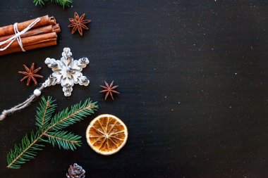 Yılbaşı yeni yıl kompozisyon kış nesneleri köknar dalı, baubles, tarçın, topu koyu siyah arka plan üzerine. Yat, görünümü, kopya alanı top. Noel Aralık zaman kutlama konsepti için