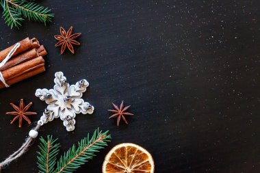 Yılbaşı yeni yıl kompozisyon kış nesneleri köknar dalı, baubles, tarçın, topu koyu siyah arka plan üzerine. Yat, görünümü, kopya alanı top. Noel Aralık zaman kutlama konsepti için