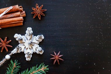 Yılbaşı yeni yıl kompozisyon kış nesneleri köknar dalı, baubles, tarçın, topu koyu siyah arka plan üzerine. Yat, görünümü, kopya alanı top. Noel Aralık zaman kutlama konsepti için