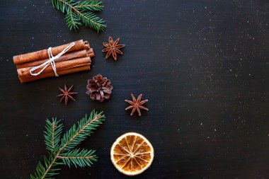 Yılbaşı yeni yıl kompozisyon kış nesneleri köknar dalı, baubles, tarçın, topu koyu siyah arka plan üzerine. Yat, görünümü, kopya alanı top. Noel Aralık zaman kutlama konsepti için