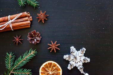 Yılbaşı yeni yıl kompozisyon kış nesneleri köknar dalı, baubles, tarçın, topu koyu siyah arka plan üzerine. Yat, görünümü, kopya alanı top. Noel Aralık zaman kutlama konsepti için