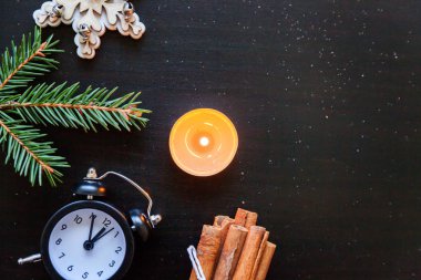 Yılbaşı yeni yıl kompozisyon kış saati, mum, köknar dalı, koyu siyah arka plan üzerine baubles nesneleri. Yat, görünümü, kopya alanı top. Noel Aralık zaman kutlama konsepti için