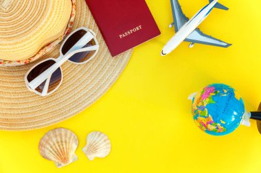 Düz şapka, uçak, pasaport, dünya, güneş gözlüğü ve kabuk sarı renkli şık modern moda zemin üzerine yatırın. Tatil seyahat yaz hafta sonu deniz macera seyahat kavramı