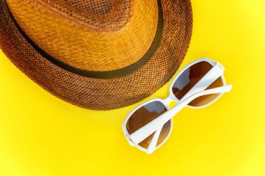 Düz sarı renkli şık modern moda arka plan üzerinde retro şapka ve güneş gözlüğü yatırın. Tatil seyahat yaz hafta sonu deniz macera seyahat kavramı